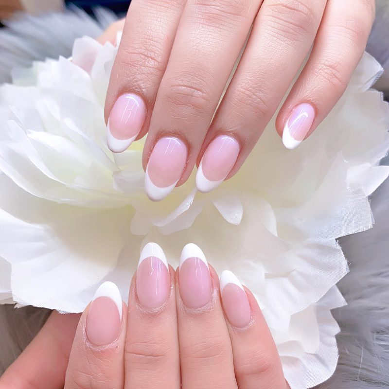 Woman with almond long pink nails design. Manicure. Nail salon. Classic bridal nail design. Summer nails